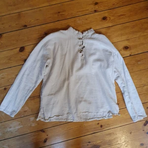 unik vintage skjorta 100% bomull - älskar denna fantstiska skjorta men använder den för lite buhu:-( den har prästkrage med såå fina träknappar (en sitter lite löst), små slits på sidorna längst ner så den sitter fint på höften, en ficka! fantastisk kvalitet🌻