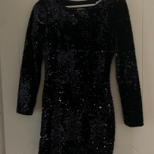 Paljettklänning - Paljettklänning från Nelly, storlek XS. Långärmad, öppen rygg. Använd en gång, bra skick!