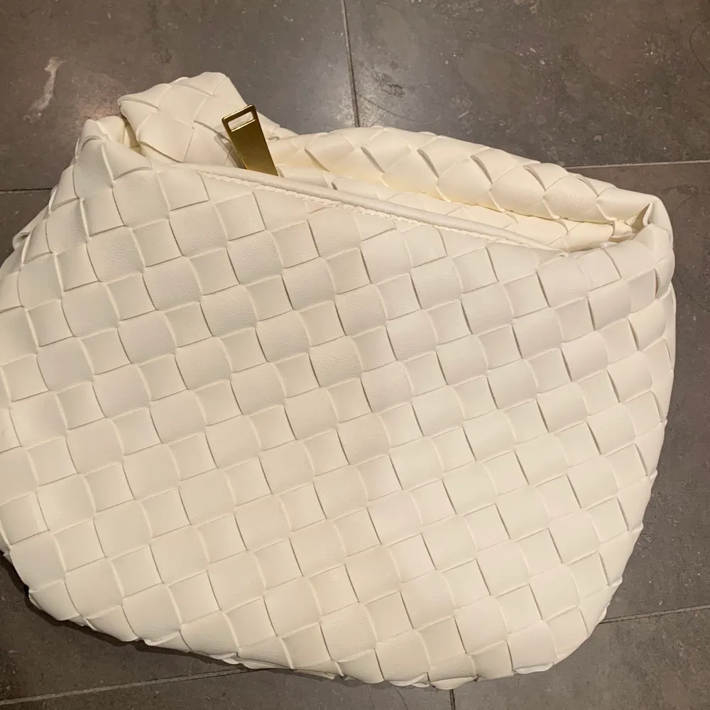 En replica av Bottega Veneta väska. Säljes i fint skick. Medföljer även dustbag samt låda. Creme färgad med gulddetaljer. . Accessoarer.