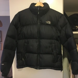 The North Face dunjacka - En dunjacka från The North Face i toppenbra skick, den är sparsamt använd av mig. Det står att det är en herrmodell, men den funkar för alla! 🥰  Jag kan mötas upp på medis/skanstull eller skicka jackan (frakt på 99kr tillkommer).   Jackan har en inbyggd luva i kragen som kan vecklas ut. Namn på modellen står ej i jackan, men den ser ut som en Nuptse: https://m.jdsports.se/product/svart-the-north-face-nuptse-1996-jacka-herr/461643_jdsportsse/?istCompanyId=8dfd7041-f89a-42e8-829b-6035ddaff452&istFeedId=3fb5d38f-c61d-4389-8259-a3dca1ef0733&istItemId=piwimtxip&istBid=tztx&gclid=EAIaIQobChMI3fGbg6_t8wIVEm8YCh2YTAwqEAQYBiABEgJ1qPD_BwE&gclsrc=aw.ds
