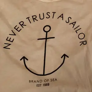 Simple classy white t-shirt with an anchor and a text saying Never trust a Sailor. From Gina tricot. Never used. 