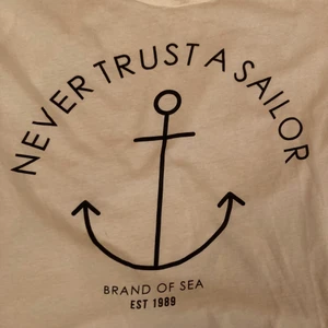 White t-shirt never trust a sailor - Simple classy white t-shirt with an anchor and a text saying Never trust a Sailor. From Gina tricot. Never used. 