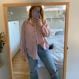 Röd vit randig skjorta  - Röd och vitrandig skjorta från Hm köpt i strl 44 då jag ville ha den i längre och mer oversized modell. Jag är en strl Xs/S i  toppar/tröjor 