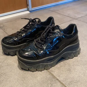 Skor från Bronx - Glansiga platåsneakers från Bronx i storlek 37. Är i fint skick förutom lite slitningar bak på hälen, se bild 3. 