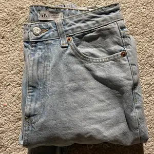 Zara mom jeans med hål i, nya och oanvända. De är i storlek 36 och de är klippta nertill. Jättefina jeans men tyvärr så kommer de inte till användning🤎 (skriv för mer bilder privat)