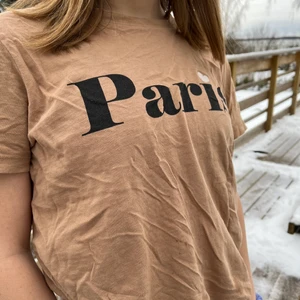  T-shirt  -  T-shirt från Lindex👍🏻 Bege T-shirt där det står ”Paris”