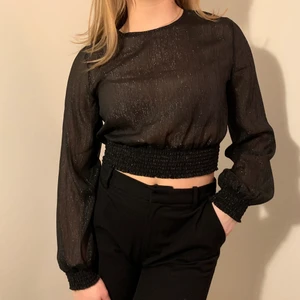 Glittrig topp! - Svart glittrig ”mesh” topp från Gina Tricot. Endast använd en gång och i nyskick! Jag är 170cm lång och har oftast S/36 i storlek.