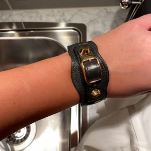 Balenciaga Armband  - Armband ifrån Balenciaga i grått och guld. Sparsamt använt. Köpt på Nathalie Shutetman i Stockholm 2017, men har tyvärr tappat boxen och äkthetsbevis. Köptes för 2000kr, men säljer för 700kr. Köparen står för frakt ❤️