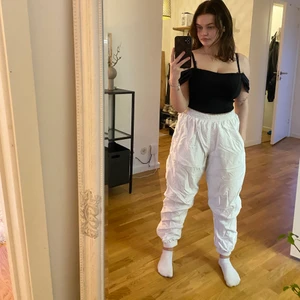 Vita trackpants - Coola trackpants från Tactel i stl M. Finns två fickor med dragkedja dessutom är det dragkedja längst ner på benen (se bild 3). Snörning i midjan finns.