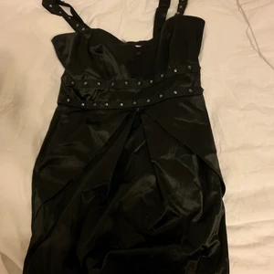 Svart klänning - Svart klänning med studsar på från ginatricot. Typ satin liknande material och studsarna är i metal. Köpt på secondhand med har aldrig använt. I storlek 36🥰 tar Swish eller kan mötas upp i Östersund 