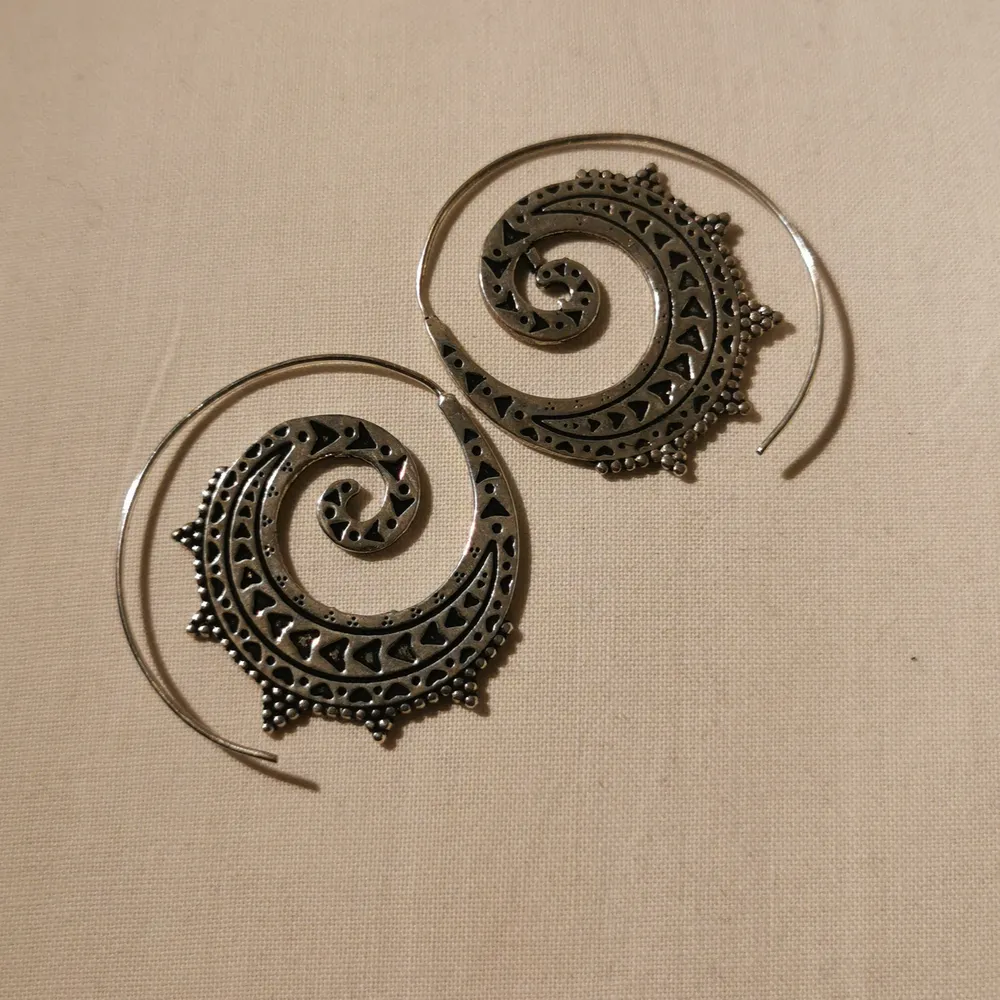 Ett par silvriga örhängen som är köpta från en tatueringsmässa för 300. Köparen står för frakten. . Accessoarer.