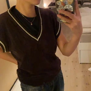 Mörkbrun v-ringad ”väst”/slipover med vita detaljer  - Mjuk och mysig mörkbrun slipover med vita detaljer. Säljer pga inte min stil/kommer inte till användning. Mjuk och passar till nästan alla årstider. Material, 20%nylon & 80%polyamid. Skick, bra/mycket bra skick då den endast är använt ett fåtal ggr men köpt på secondhand. Vid intresse/frågor/fler bilder skriv till mig under annonsen (kontakta). Upphämtning på Södermalm eller frakt till självkostnadspris.<3 (välj själv om du vill ha spårbart elr ej)