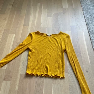 Senapsgul långärmat topp - Långärmad topp. Storlek 40