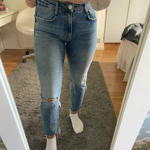 Blå jeans med hål på knäna från zara i storlek 38