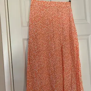 Säljer min orangea blommiga kjol från HM, storlek 36
