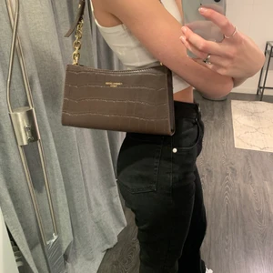 Brun trendig baguettväska - Så fin och trendig baguettväska!! Säljer för den aldrig kommit till användning😕 ingår även ett längre band som man kan byta ut om man önskar en crossbody bag 💞