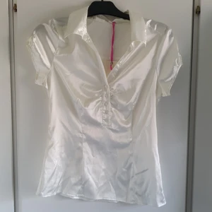 NY snygg vit blus !! - En snygg blus som inte är använd. Lappar sitter kvar. Fin till vår & sommar! Jag kan skicka med frimärke för 26 kr alternativt postnord skicka lätt spårbart för 66 kr.🤗