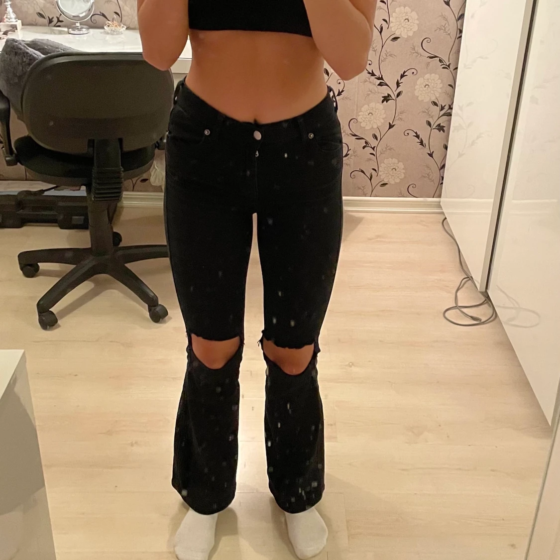 Svarta utsvängda byxor, med hål i