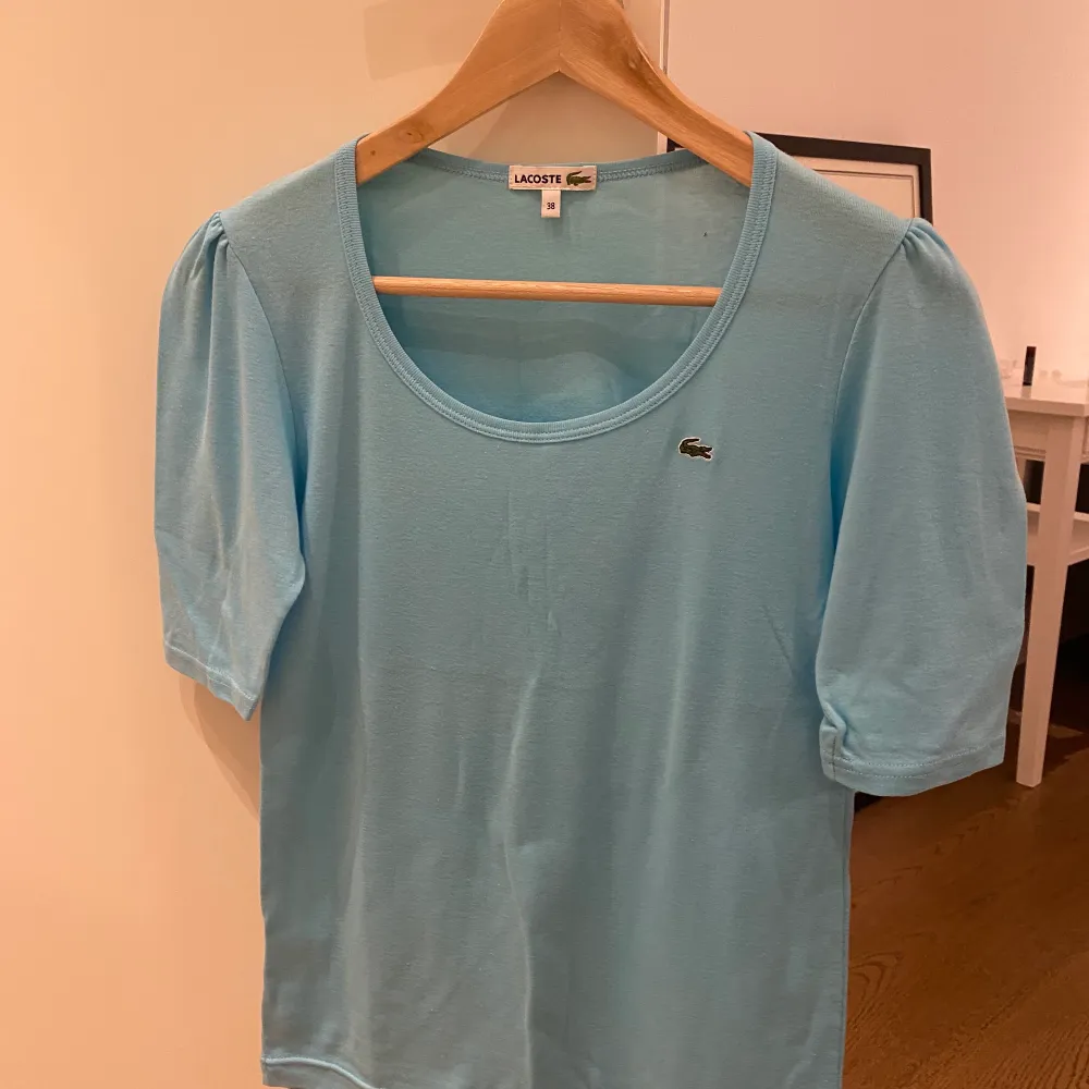 Ljusblå Lacoste t-shirt för 100 kr.. T-shirts.