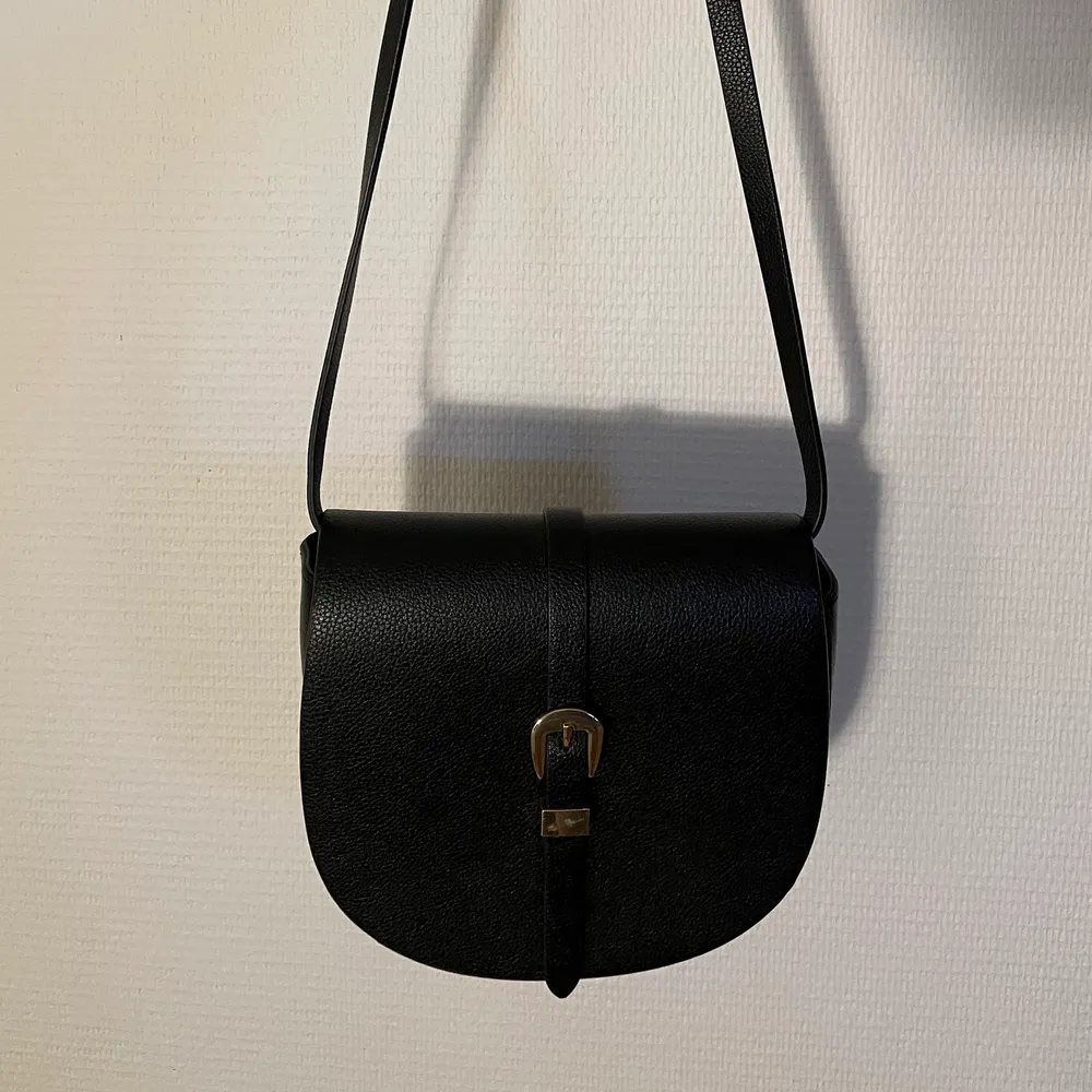 Svart hm väska med justerbart band, antingen kan du ha den som en väska med kort band på axeln, eller långt band tvärs över bröstet. Köparen står för frakten💖. Väskor.