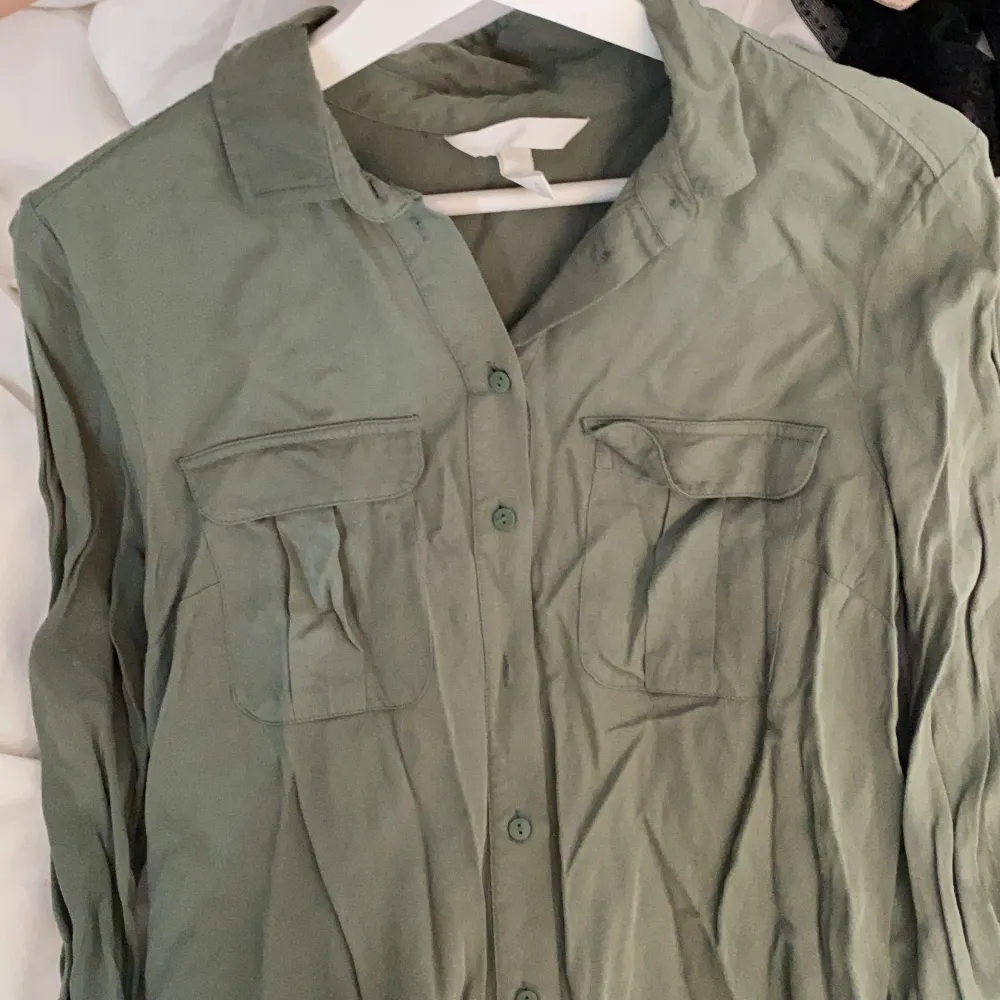 Mörk grön skjorta från H&M. Skulle säga att den är väldigt liten i storleken. Den är i 38 men skulle säga att det är 34/36🤍🤍 den är inte rynkad men har inte strukit den!!. Skjortor.