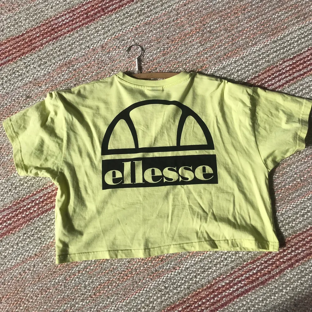 En ljusgul Ellesse t-shirt med text fram och bak, skicket är som ny!. T-shirts.