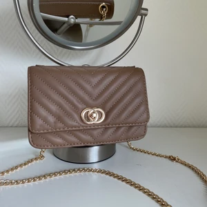 Brun handväska - Håller på att flytta så hitta en massa saker som inte används. Här är en helt oanvänd mindre handväska som man både kan ha långt och kort band på. Säljer denna för 100kr.  Kan skickas iväg då tillkommer frakt men även lämnas om det är i närheten.