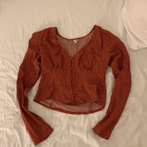 Blus  - Supersöt röd blus med vita prickar. Snygg formning runt axlar och bröst