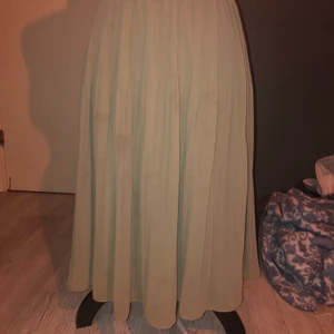 Långkjol strl.38 - En sagegreen långkjol som är sååå skön och fin att ha på sommar dagar då det är för kallt att ha shorts eller kortare kjolar men för varmt med jeans. Den är ribbad precis under midjebandet.