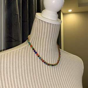 Halsband i stenar i olika färger. Justerbart halsband och använt endasst en gång