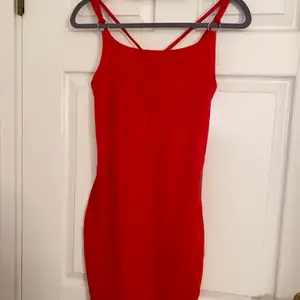 Röd klänning med korsning på ryggen, figursydd, endast använd 1 gång.