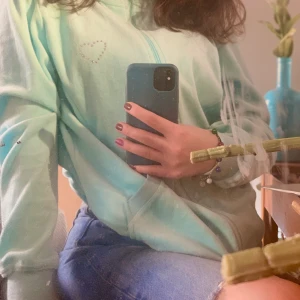 Y2K KOFTA - En baby blå kofta. Den har en super söt detalj på bröstet (ett litet hjärta) Jag har alldeles för många koftor så denna rensas ut! Den kan bli till en turtle neck kofta om man drar upp dragkedjan hela vägen