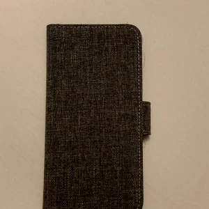 Plånboksskal från Holdit till IPhone  - Säljer ett grått mobilskal från Holdit. Passar till 6 / 6S, 7, 8 och SE. Nyckick. 100kr. Köparen står för frakten :) 