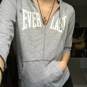 Grå topp - Snygg grå topp med luva från Everlast. Jätteskönt material. Ganska liten i storleken