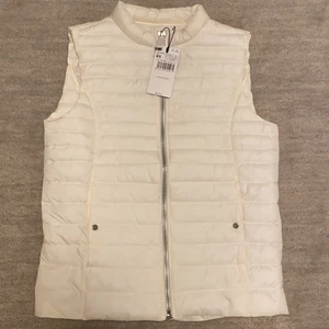 Vit väst från Mango - Helt oanvänd, köpt för 299kr, Dragkedja, har två fickor med en varsin knapp på sidan, utan luva, silver detaljer