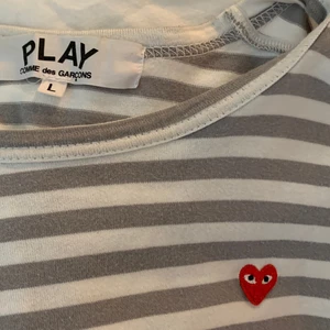 Vit grå randig cdg tröja  - Jättefin tröja från comme des garcons, använd men i fint skick. Den har dock en liten fläck vid ryggen men den syns ej på! Nypris är 1500kr, är köpt i storlek L men sitter som en xs-s👍🏼😄
