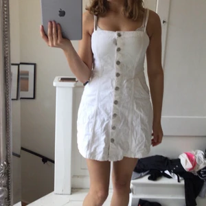 En jeanskläning i stl 36 - En vit och söt jeanskläning som passar perfekt till sommaren. 