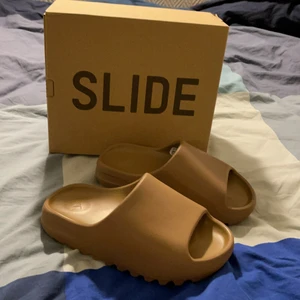 Adidas Yeezy Slide - Hej! Säljer ett par helt nya och oanvända Yeezy Slides i storlek US 5/EU 38. Köpta ifrån SNS, kvitto medföljer givetvis. Om du vill ha fler bilder, skickar jag gärna. Jag kan mötas upp i GBG, men kan självklart frakta dem till dig, på din bekostnad. Hör gärna av dig om du har fler frågor! 