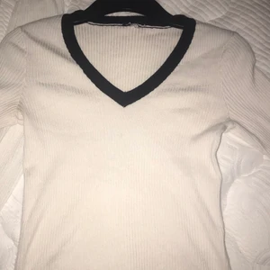 Urringad vit t-shirt - En urringad vit t-shirt med svart detalj. Använt flertal gånger men fortfarande i bra skick.