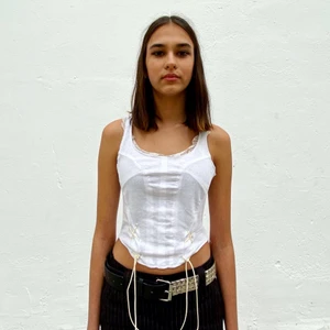 Topp no: 1 - Ezzie x Plick - Vit topp med spetsdetaljer och vit snörning. Gjord från secondhand t-shirts. Designad av Ezzie i samarbete med Ebba Martin.  (Shipping outside of Sweden costs extra, DM for further info)