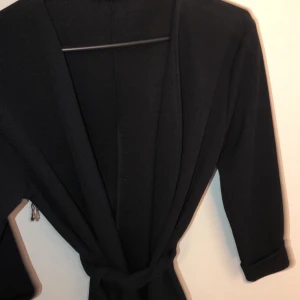 Svart kavaj - Svart kavaj med knyt i midjan! Storlek S, aldrig använd då den var för liten på mig.. Superfin och trendig 