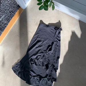 Svart omlottkjol - Svart omlottkjol i stolek 38:) Tunn men ej genomskinlig så är utmärkt till svalare sommarkvällar! Har även knapp på insidan så sitter säkert! 