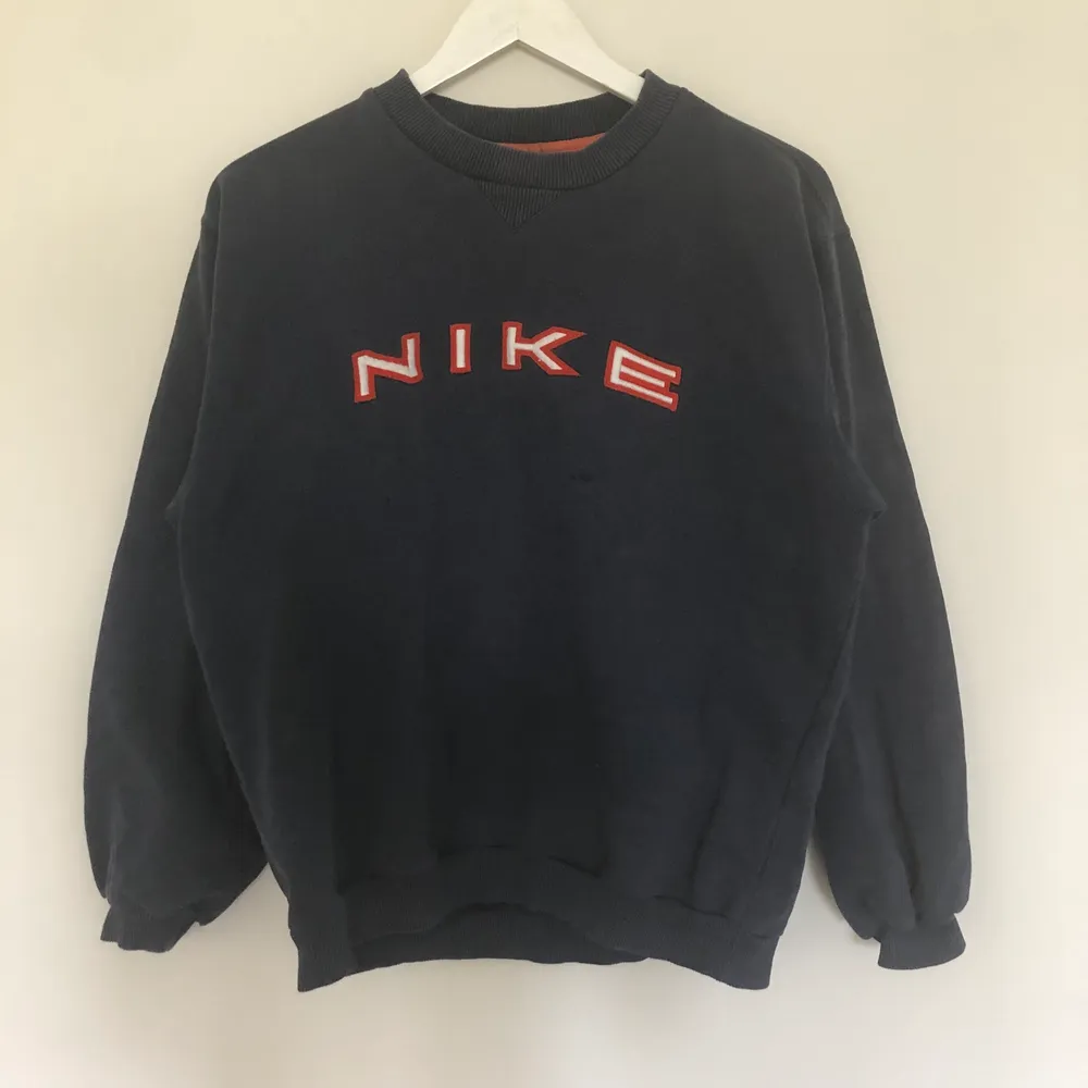 Vintage Nike Spellout Sweatshirt i Mörkblå färg. Texten är i orange och vit färg. Storlek small men borde passa medium. Från 90-talet. Tröjan har tyvärr ett par fläckar, skriv till mig så skickar jag:). Tröjor & Koftor.