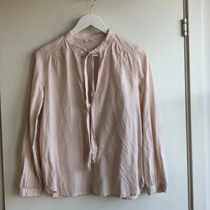 Filippa K Blus - Blus. Ljust rosa. Knyt i hals. Filippa K. Det står storlek L i blusen men jag skulle säga den motsvarar stlk 36.
