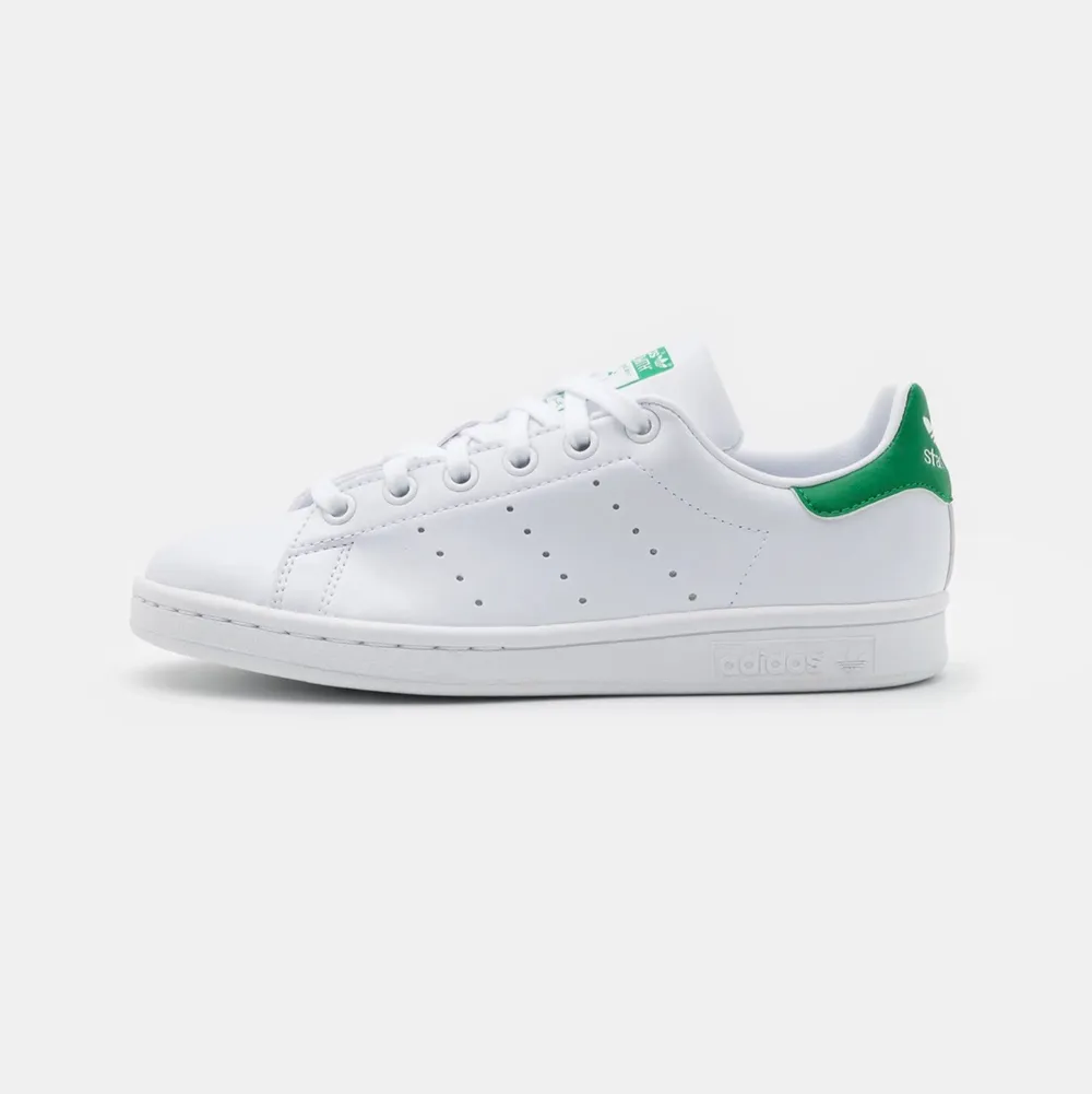 Säljer ett par vita sneakers med gröna detaljer. Det är ett par stan smith från adidas. De är sparsamt använda i bra skick.    Köpare står för frakt.. Skor.