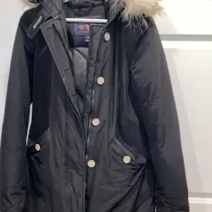 Äkta Woolrich jacka i storlek XS, jätte fin passform som formar sig inåt mot midjan. Den är i färgen svart och har bytt mot pälsen mot vit päls istället. Det ser mycket finare ut med vitt tycker jag personligen. 