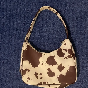 Handväska med cowpattern  - Super fin väska från monki, helt oanvänd och i toppen skick! Finns i stockholm