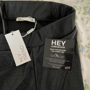 Skinnbyxor med slits, XL - Säljer ett par nyköpta skinnbyxor med slits och dragkedja i bak från Nelly.com. Säljer pågrund av att de var för stora i midjan och lite för korta i benen, (jag är 178 cm). Köparen står för frakten😊😊