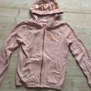 Rosa hoodie  - Säljer denna rosa hoodie med dragkedja. På bröstet står det brklyn dreamers. Och det står även Brklyn på luvan. Inuti är den i ett gosigt material. Den är använd i bra skick och perfekt att ha som mjukiskofta. Rekommenderar för 12-14 år.