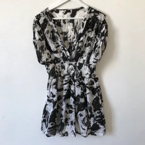 Svartvit klänning, XS-S, 100% bomull  - Oanvänd mönstrad klänning från Vila i svart/grå/vit. Resår i midja och korta ärmar, V-ringad, lite krispigt bomullstyg men ändå fint fall.  Kan mötas i Stockholm eller skicka mot fraktkostnad! ✨🌸✨